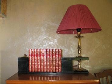Collage de livres et lampe cuivre.